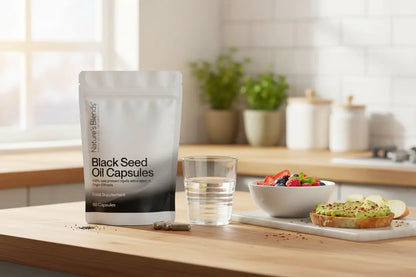 Black seed oil capsules UK lifestyle — Nature's Blends pouch with healthy kitchen spread
